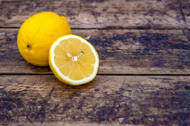 Taze organik limonlar Yaz meyveleri, eski ahşap masa, durgun yaşam, yeşil arka plan ağaç gövdesi açık hava, olgun sarı