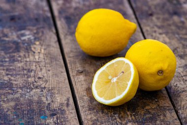 Taze organik limonlar Yaz meyveleri, eski ahşap masa, durgun yaşam, yeşil arka plan ağaç gövdesi açık hava, olgun sarı