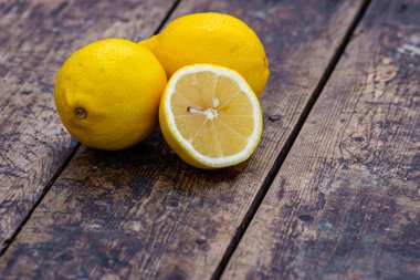 Taze organik limonlar Yaz meyveleri, eski ahşap masa, durgun yaşam, yeşil arka plan ağaç gövdesi açık hava, olgun sarı