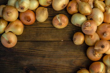 Tahta masada taze kırmızı soğan, üst görünüm, organik gıda kahverengi dilimler, hasır sepetin dışındaki sade ham kesim tahtası Ampul Gıda yerel çiftçi marketini içeriyor