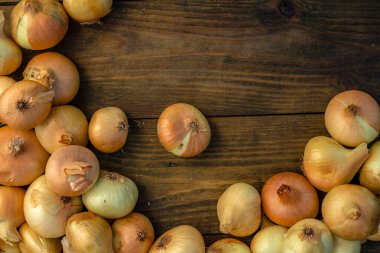 Tahta masada taze kırmızı soğan, üst görünüm, organik gıda kahverengi dilimler, hasır sepetin dışındaki sade ham kesim tahtası Ampul Gıda yerel çiftçi marketini içeriyor