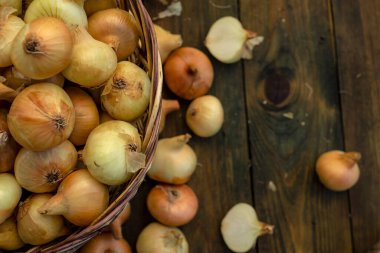 Tahta masada taze kırmızı soğan, üst görünüm, organik gıda kahverengi dilimler, hasır sepetin dışındaki sade ham kesim tahtası Ampul Gıda yerel çiftçi marketini içeriyor