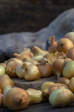 Tahta masada taze kırmızı soğan, üst görünüm, organik gıda kahverengi dilimler, hasır sepetin dışındaki sade ham kesim tahtası Ampul Gıda yerel çiftçi marketini içeriyor
