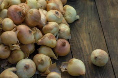 Tahta masada taze kırmızı soğan, üst görünüm, organik gıda kahverengi dilimler, hasır sepetin dışındaki sade ham kesim tahtası Ampul Gıda yerel çiftçi marketini içeriyor