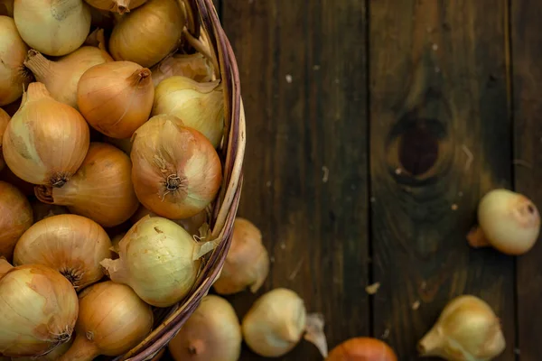 Tahta masada taze kırmızı soğan, üst görünüm, organik gıda kahverengi dilimler, hasır sepetin dışındaki sade ham kesim tahtası Ampul Gıda yerel çiftçi marketini içeriyor