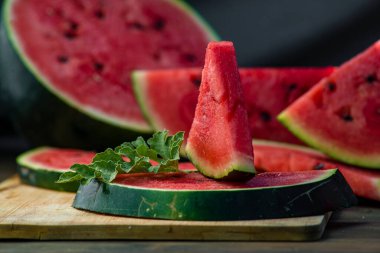 Lezzetli karpuz açık hava ahşap masa, yeşil doğal arka plan dilimleme güneşli gün, hurda, taze olgun kırmızı yaprak, yaz güneşli bahçe suyu organik tatlı meyve, vejetaryen yemeği lezzetli dilimlenmiş tahta tabak