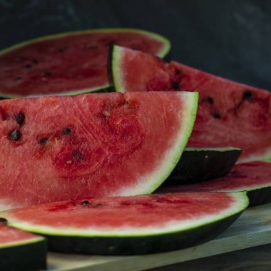 Lezzetli karpuz açık hava ahşap masa, yeşil doğal arka plan dilimleme güneşli gün, hurda, taze olgun kırmızı yaprak, yaz güneşli bahçe suyu organik tatlı meyve, vejetaryen yemeği lezzetli dilimlenmiş tahta tabak