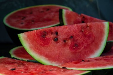 Lezzetli karpuz açık hava ahşap masa, yeşil doğal arka plan dilimleme güneşli gün, hurda, taze olgun kırmızı yaprak, yaz güneşli bahçe suyu organik tatlı meyve, vejetaryen yemeği lezzetli dilimlenmiş tahta tabak