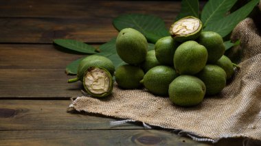 Yeşil ceviz çekirdekleri, ahşap masa yağı fındık olgunlaşmamış kabuklar sağlıklı yiyecek, eski kırsal masa özgeçmişi hasat, organik ev yapımı bitki sütü sütü sütsüz cam bardak.