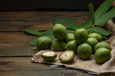 Yeşil ceviz çekirdekleri, ahşap masa yağı fındık olgunlaşmamış kabuklar sağlıklı yiyecek, eski kırsal masa özgeçmişi hasat, organik ev yapımı bitki sütü sütü sütsüz cam bardak.