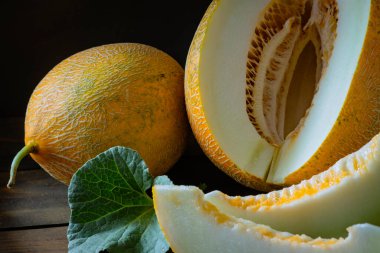 fresh Whole and sliced of Japanese melons, honey melon cantaloupe (Cucumis melo) leaf wooden table background. fruit summer Fruits healthcare concept. dark Food backdround Still Life squash