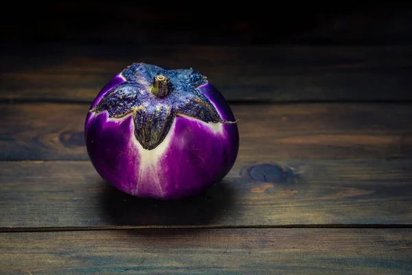 Violet purple Round eggplant, dark food photography, moody background closeup. Selective focus, aubergine Melanzana