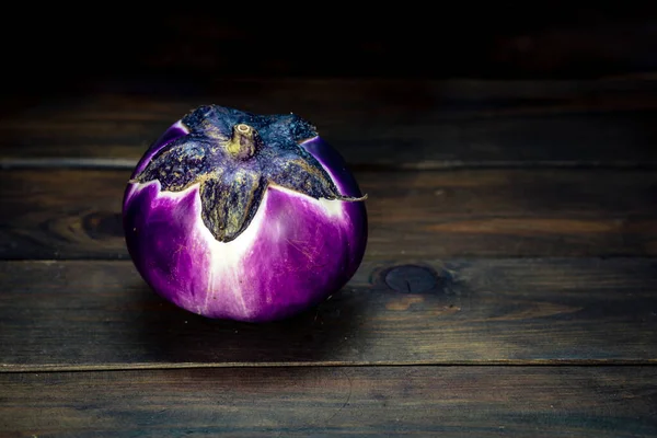 Violet purple Round eggplant, dark food photography, moody background closeup. Selective focus, aubergine Melanzana