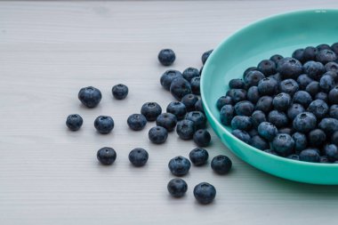 Fresh Blueberries blueberry BowlTable Freshly picked turquoise bowl. Juicy and fresh blueberries Bilberry white wood food Background. antioxidant. Concept healthy eating nutrition fruit  top view.