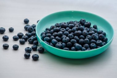 Fresh Blueberries blueberry BowlTable Freshly picked turquoise bowl. Juicy and fresh blueberries Bilberry white wood food Background. antioxidant. Concept healthy eating nutrition fruit  top view.