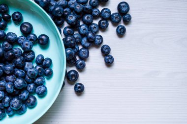 Fresh Blueberries blueberry BowlTable Freshly picked turquoise bowl. Juicy and fresh blueberries Bilberry white wood food Background. antioxidant. Concept healthy eating nutrition fruit  top view.