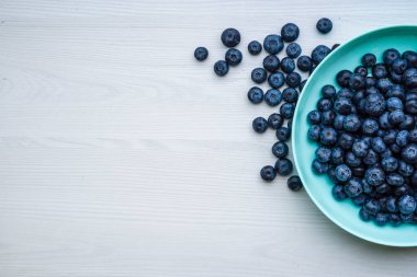 Fresh Blueberries blueberry BowlTable Freshly picked turquoise bowl. Juicy and fresh blueberries Bilberry white wood food Background. antioxidant. Concept healthy eating nutrition fruit  top view.