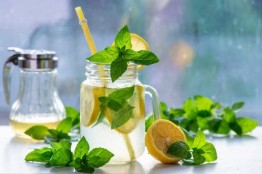 Mojito cocktail or mocktail with lemon, mint, and ice honey in glass jar Summer cold alcoholic non-alcoholic drink, beverage Copy space table