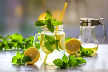 Mojito cocktail or mocktail with lemon, mint, and ice honey in glass jar Summer cold alcoholic non-alcoholic drink, beverage Copy space table