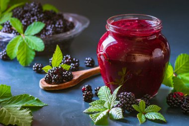 Tasty blackberry jam fresh berries, table raw Fresh homemade  green leaves Berries organic harvest forest still life glass jar wood spoon Dark background
