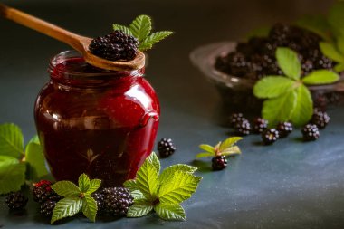 Tasty blackberry jam fresh berries, table raw Fresh homemade  green leaves Berries organic harvest forest still life glass jar wood spoon Dark background
