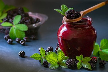 Tasty blackberry jam fresh berries, table raw Fresh homemade  green leaves Berries organic harvest forest still life glass jar wood spoon Dark background