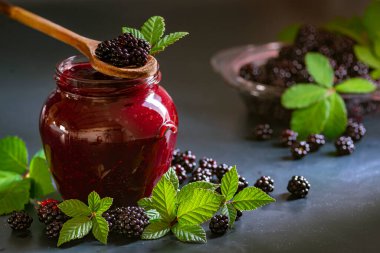 Tasty blackberry jam fresh berries, table raw Fresh homemade  green leaves Berries organic harvest forest still life glass jar wood spoon Dark background