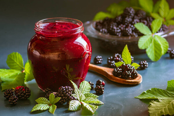 Tasty blackberry jam fresh berries, table raw Fresh homemade  green leaves Berries organic harvest forest still life glass jar wood spoon Dark background
