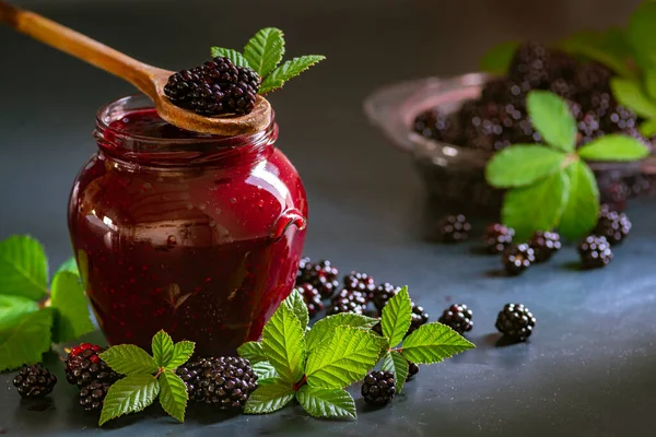 Tasty blackberry jam fresh berries, table raw Fresh homemade  green leaves Berries organic harvest forest still life glass jar wood spoon Dark background