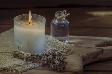 Glass bottle Lavender essential oil dried seed  aromatherapy spa massage concept. herb Purple candle wood table background sea salt still life rustic cutting board napkin