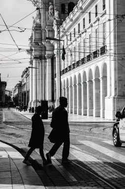 Silhouette people walk on pedestrian crosswalk at the junction street of business city at the evening sunset with the dark shadow of people on the road