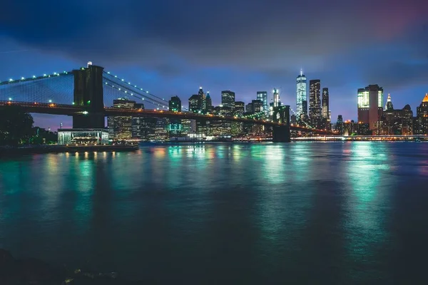 Бруклинский мост ночью с отражением воды в Нью-Йорке — стоковое фото