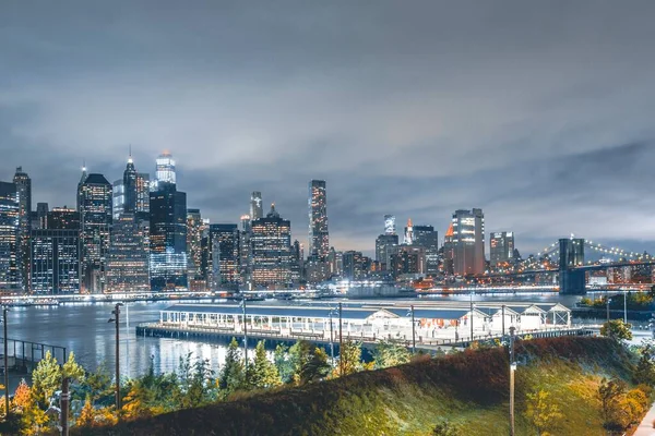 Brooklynský most v noci s reflexí vody v New Yorku — Stock fotografie