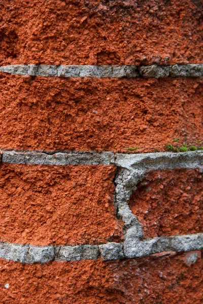Kırmızı tuğla ve çimento harçtan yapılmış eski bir tuğla duvarın parçası.