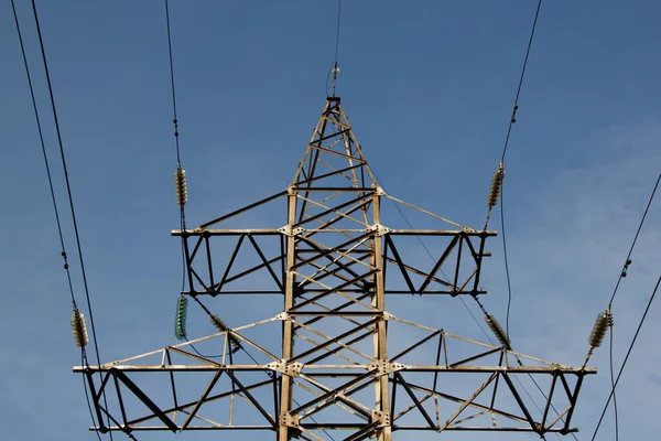 Mavi gökyüzünün arka planında yüksek voltajlı elektrik hatları
