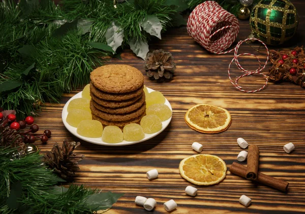 Ev yapımı bisküviler, marmelat ve Noel süslemeleri ahşap bir masada.