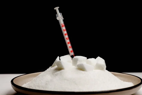 large amount of sugar on the plate and insulin syringe