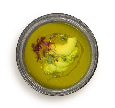 Beyaz arka planda izole edilmiş taze aromatik otlu avokado püresi çorbası.