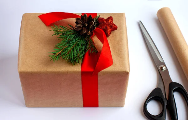 Stap voor stap. Stap 3. Wikkel een kerstcadeau in ambachtelijk papier en versier het met dennentakken en kerstspeelgoed. Instructies voor cadeauverpakkingen. — Stockfoto