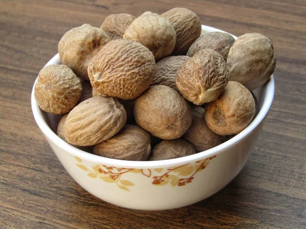 Nutmeg Dalam Mangkuk Latar Belakang Kayu — Stok Foto