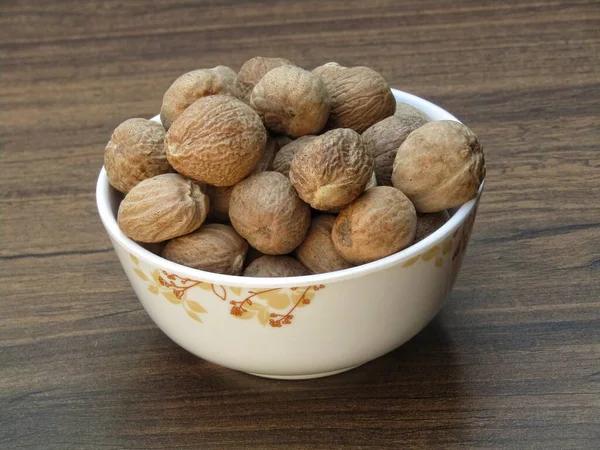 Nutmeg Dalam Mangkuk Latar Belakang Kayu — Stok Foto