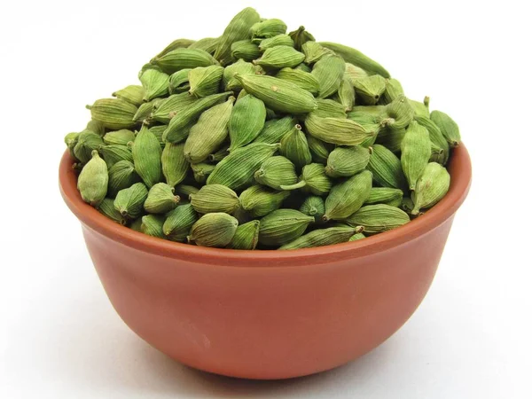 Beyaz arka planda izole edilmiş bir kasede yeşil kakule. 