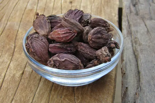 Eski Ahşap Arka Planda Bir Kasede Siyah Kakule — Stok fotoğraf