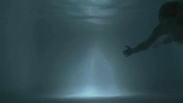 Девушка плавает на поверхность под водой — стоковое видео