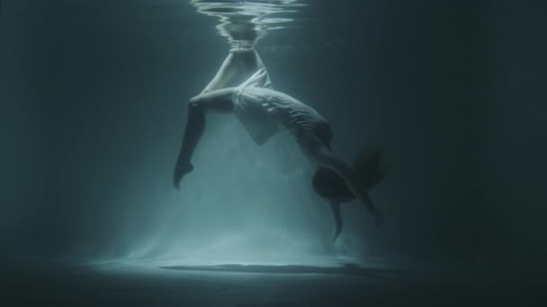 Unterwassergymnastik eines schönen Mädchens in einem weißen Kleid — Stockvideo