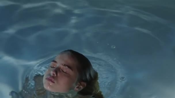 Uma menina com cabelo vermelho em câmera lenta emergiu da água — Vídeo de Stock