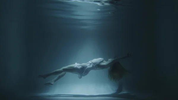 Дівчина в білій сукні плаває під водою — стокове фото