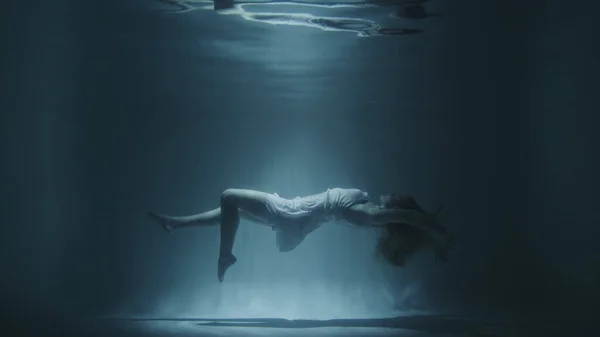 Beyaz elbiseli kız suyun altında yüzüyor. — Stok fotoğraf