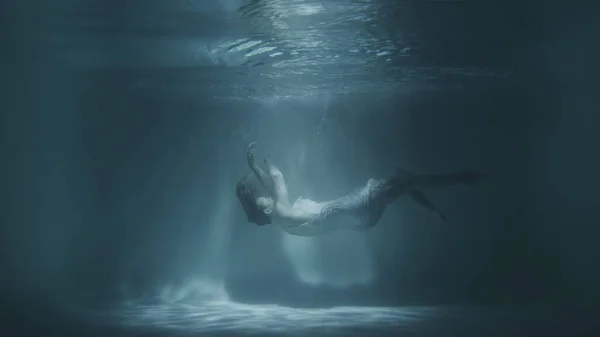 Una chica en un vestido blanco cae bajo el agua —  Fotos de Stock