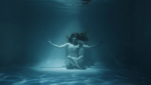 Mujer pelirroja meditando bajo el agua en vestido blanco —  Fotos de Stock